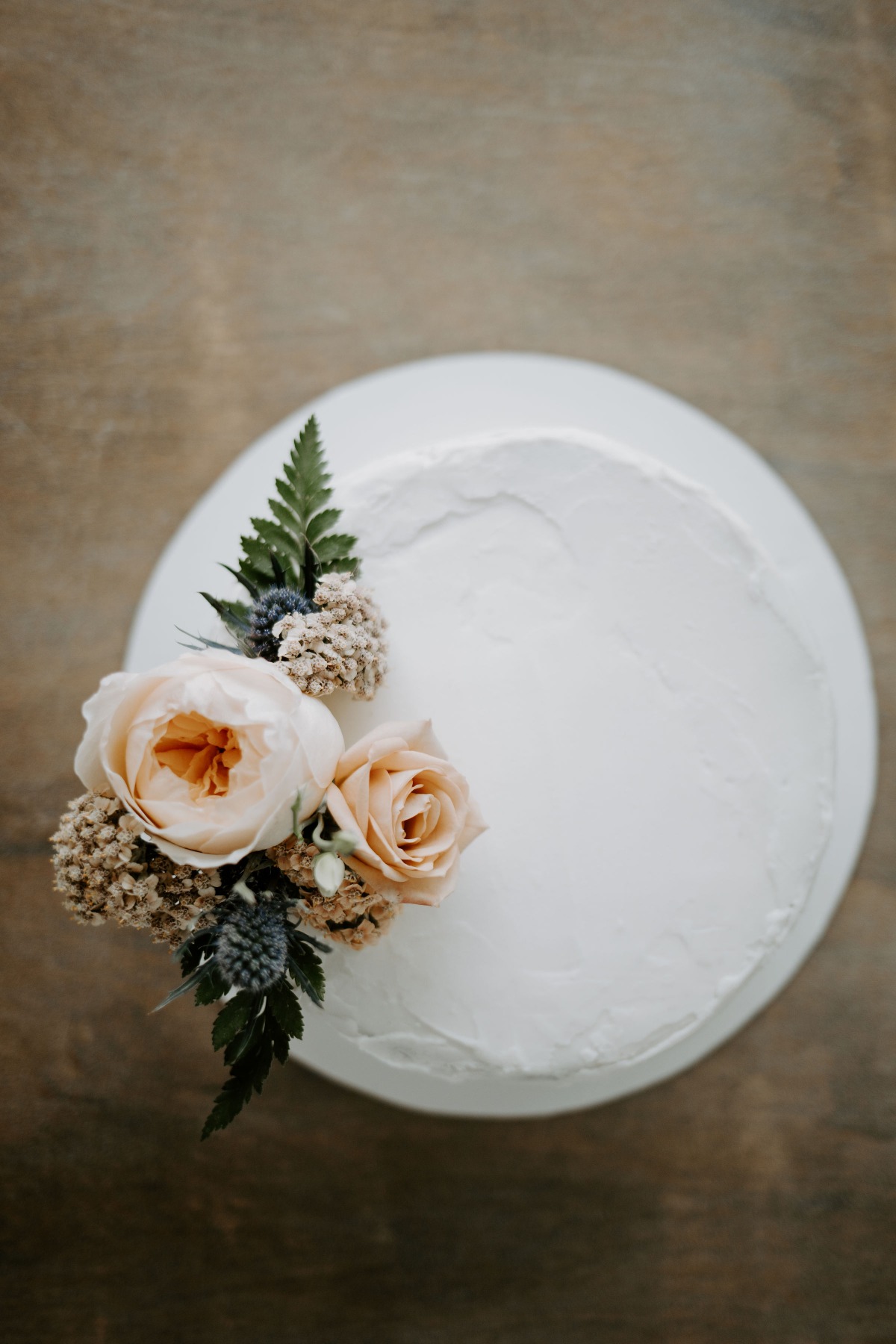 Elegant white wedding cake decorated with soft blush roses
