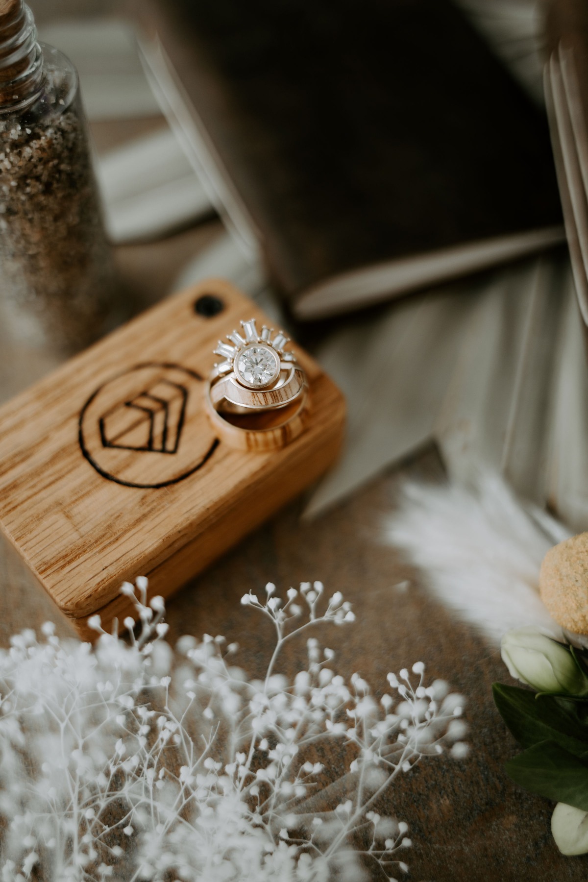 Elegant diamond rings on a wooden ring box with floral accents