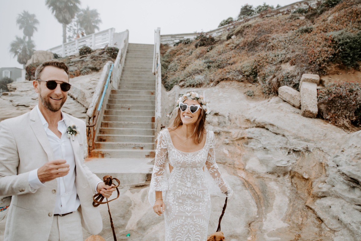 Happy couple walking their dog, enjoying a beautiful wedding day