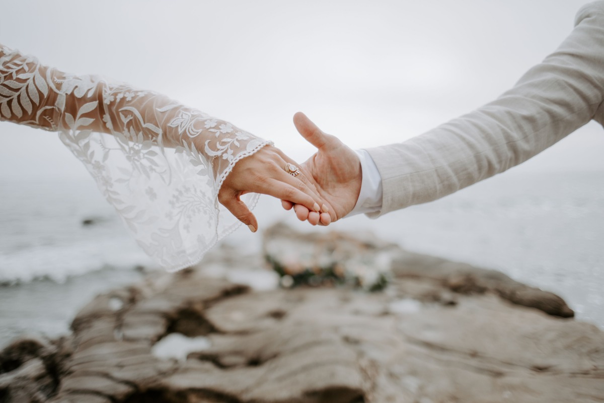 Bride and groom holding hands, wedding ring visible