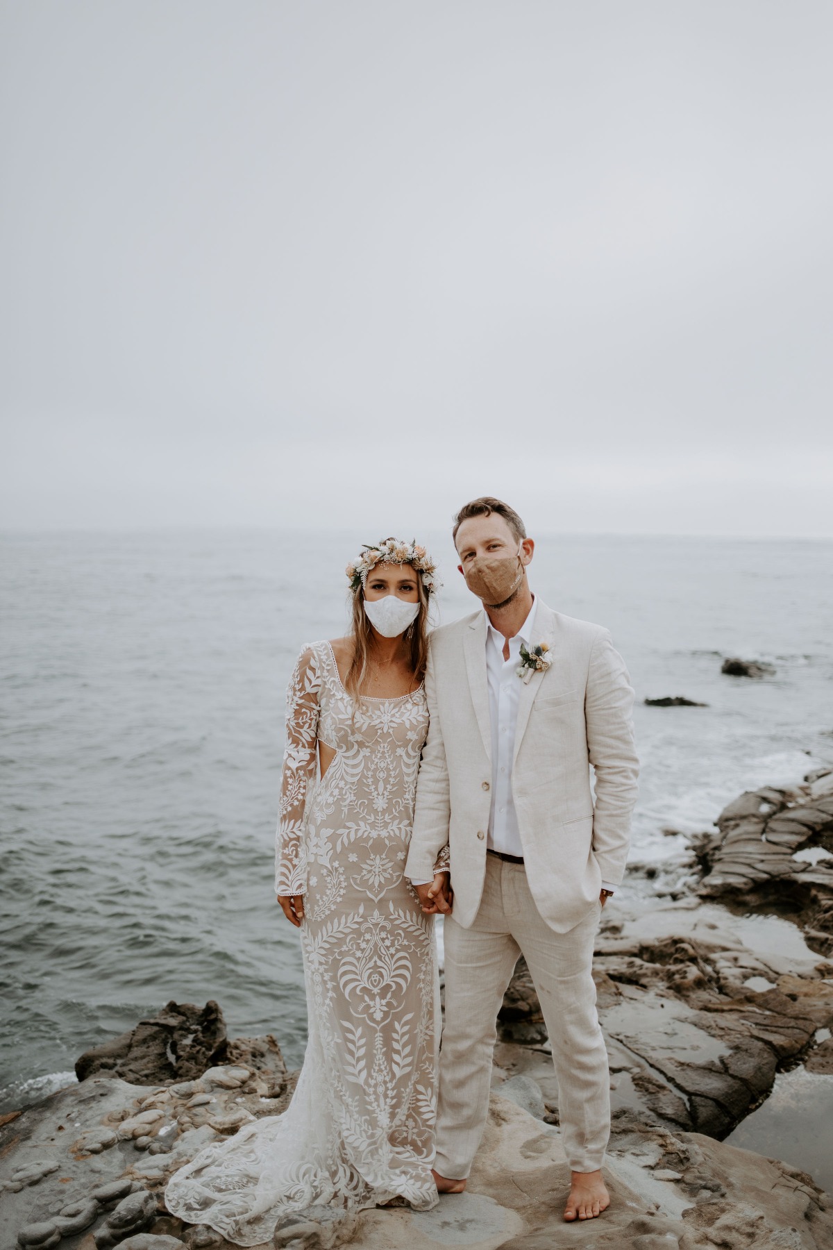 Bride and groom wearing masks at their oceanside wedding