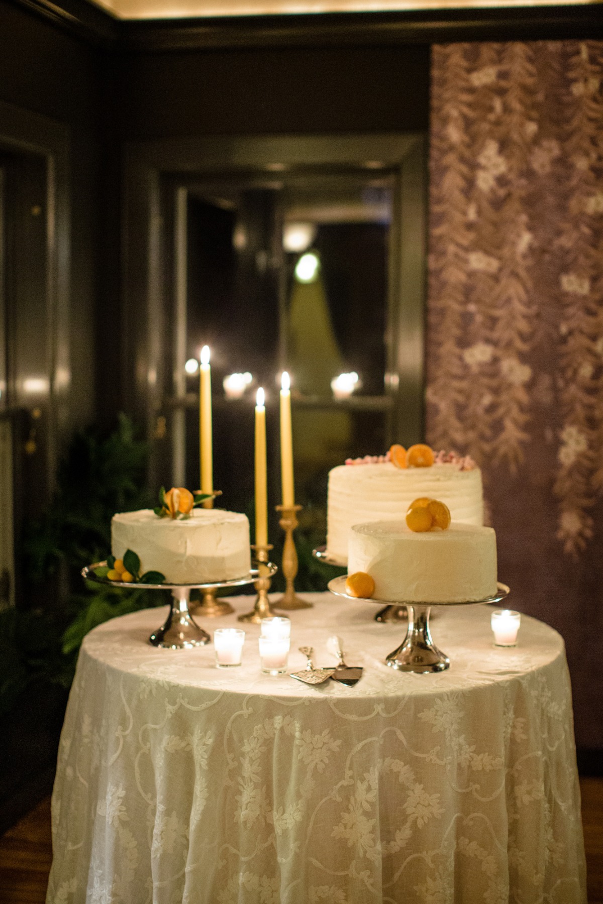 Elegant cakes decorated with oranges and candles on a round table