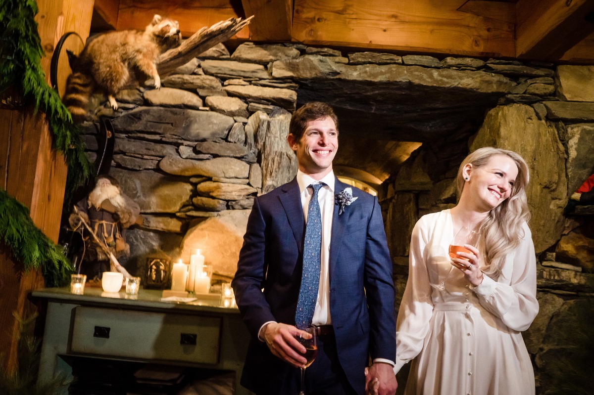 Happy couple smiling in a rustic setting with raccoon decor