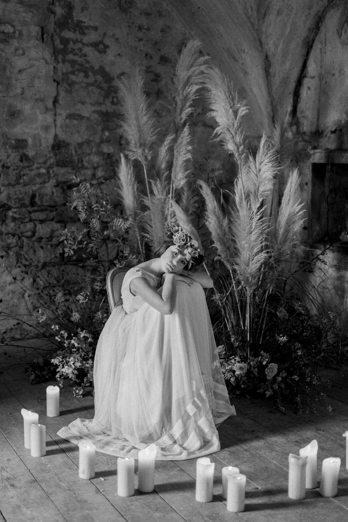 Bride in a dreamy dress surrounded by candles and pampas grass