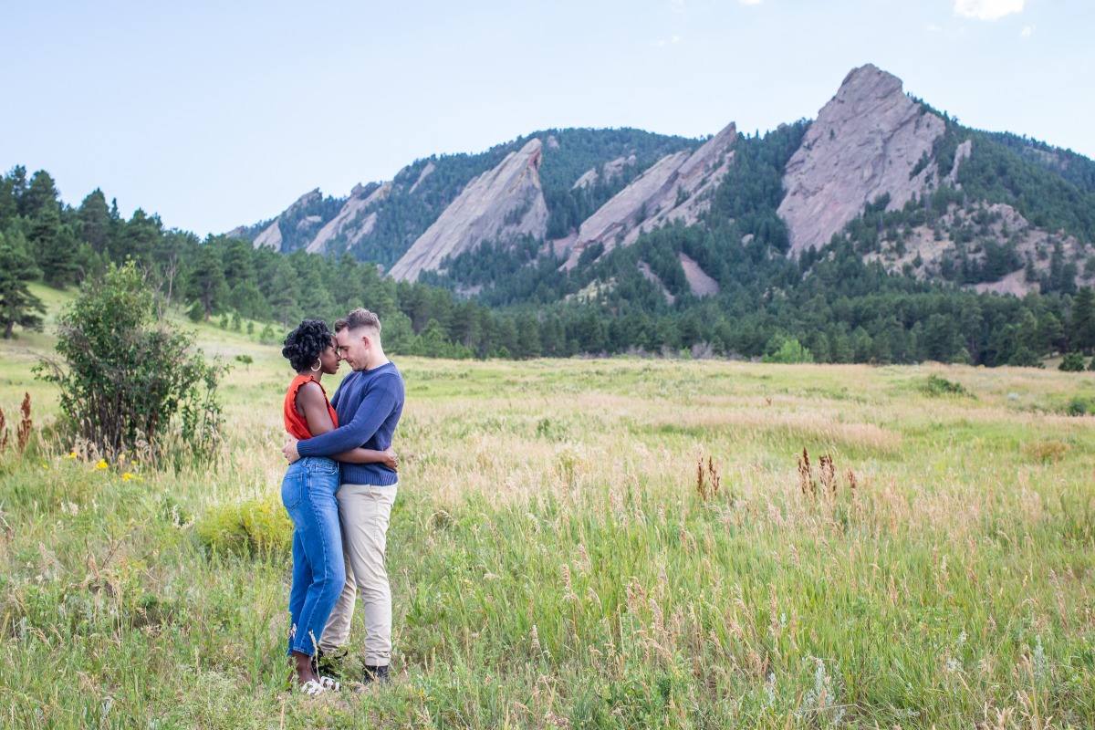 Couple embracing in a scenic mountain field