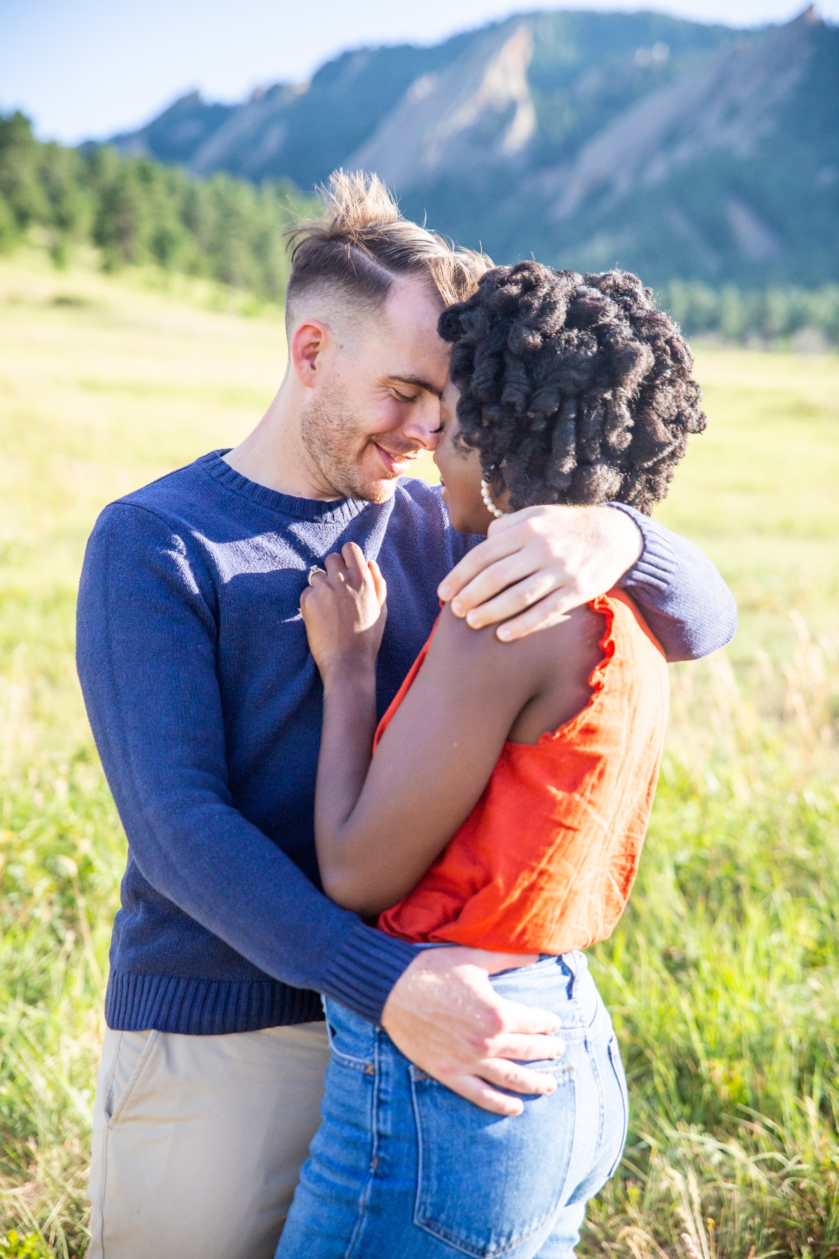 Couple embracing in a scenic mountain field