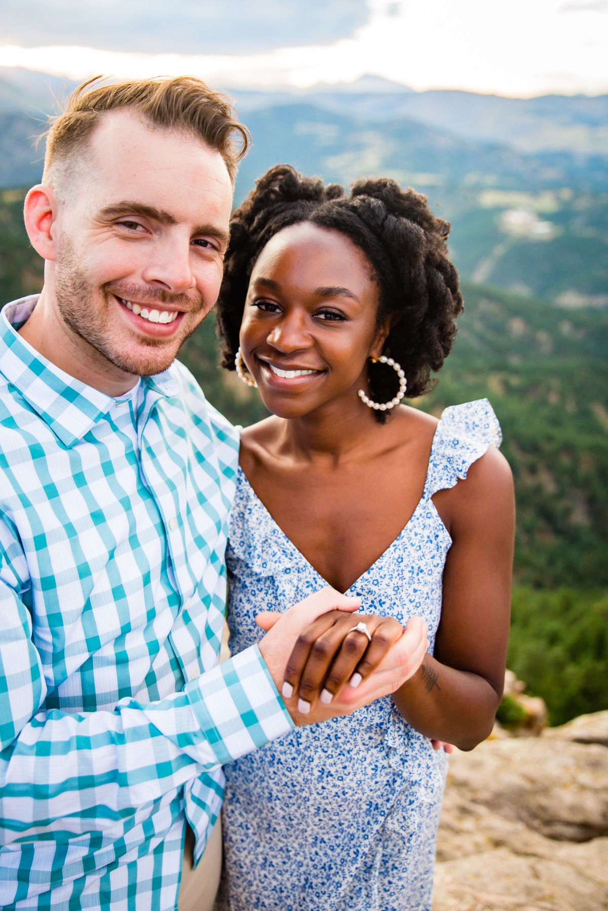 Happy couple shows off engagement ring in mountains
