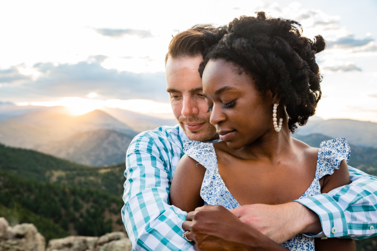 Romantic couple embraces at sunset mountaintop