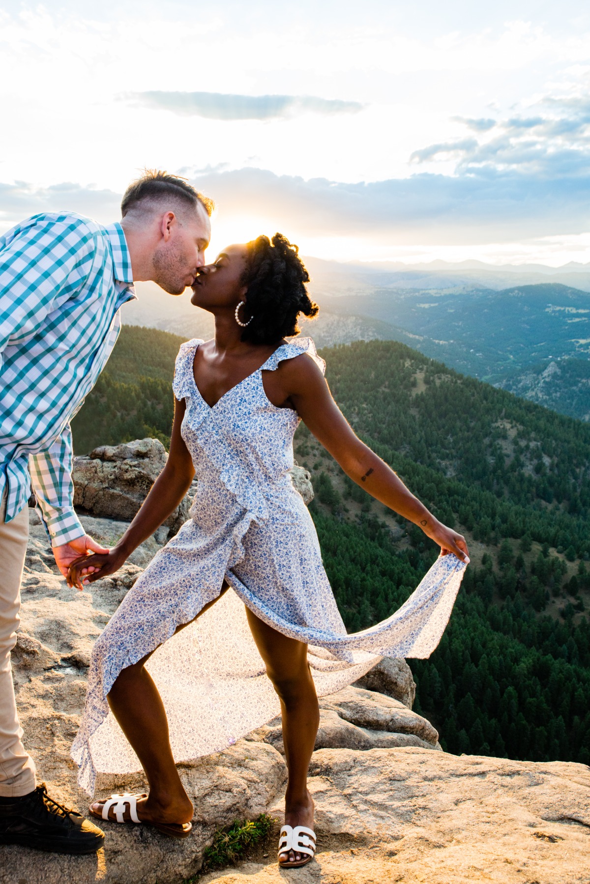 Couple kissing on mountaintop at sunset