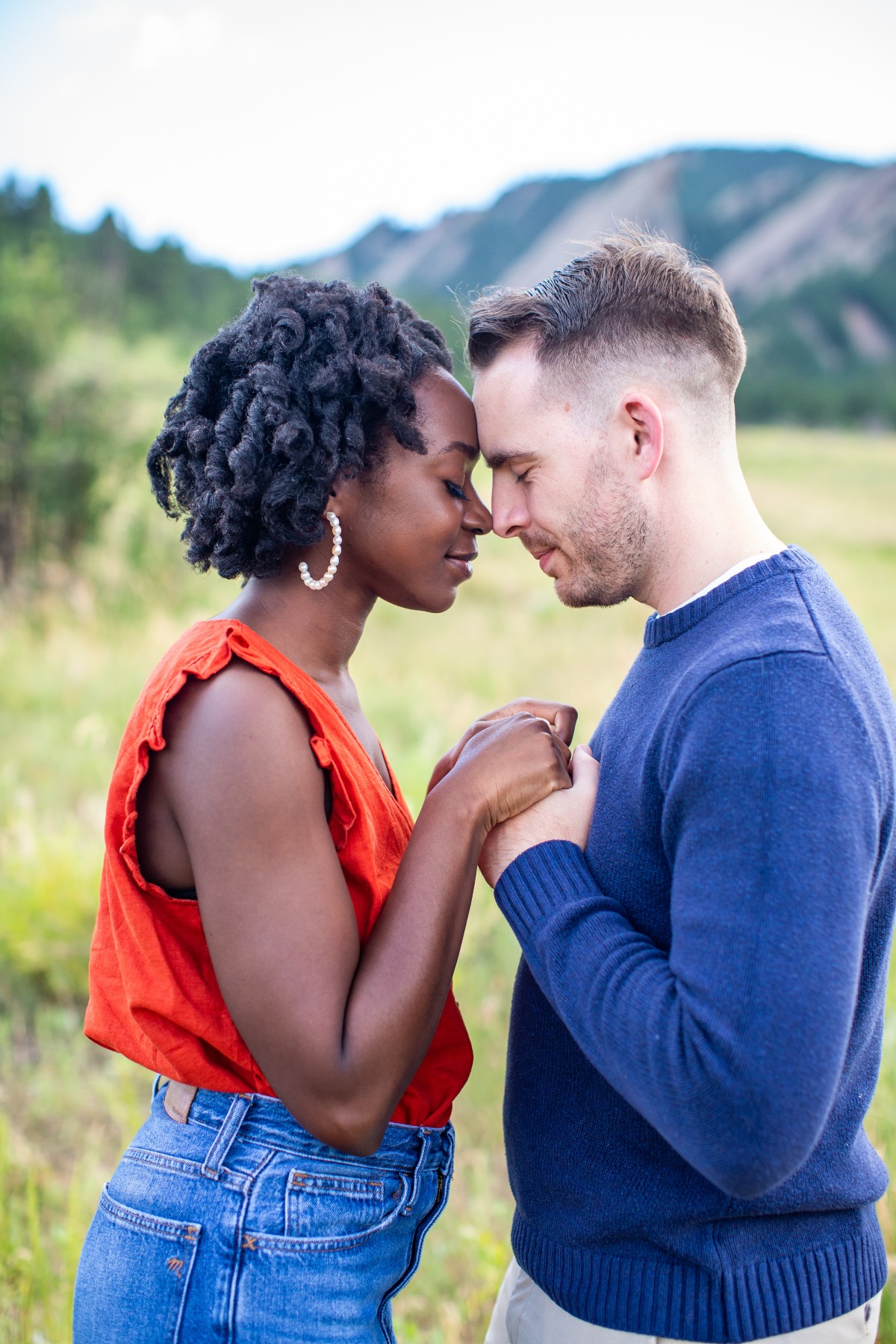 Loving couple holding hands, foreheads touching