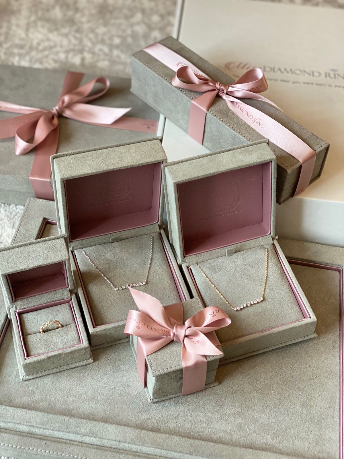 Elegant diamond jewelry in gift boxes with pink ribbons