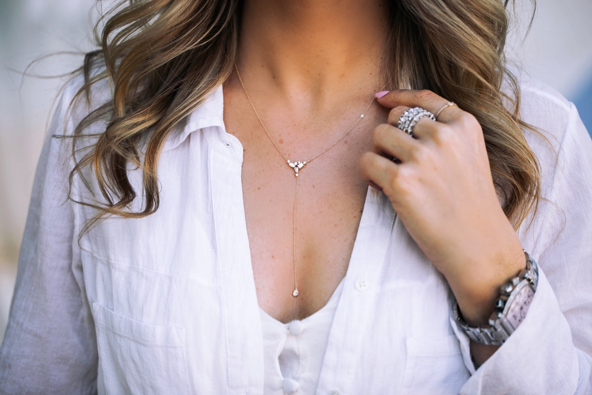 Woman wearing a diamond necklace and rings with watch