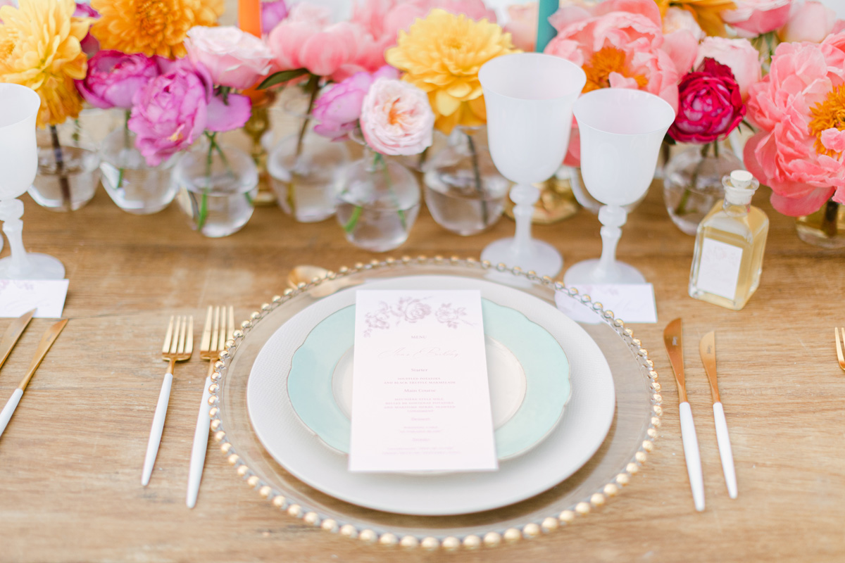 Elegant floral table setting with gold flatware and chargers