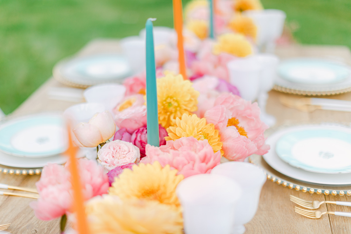 Floral centerpiece with colorful candles on wedding table