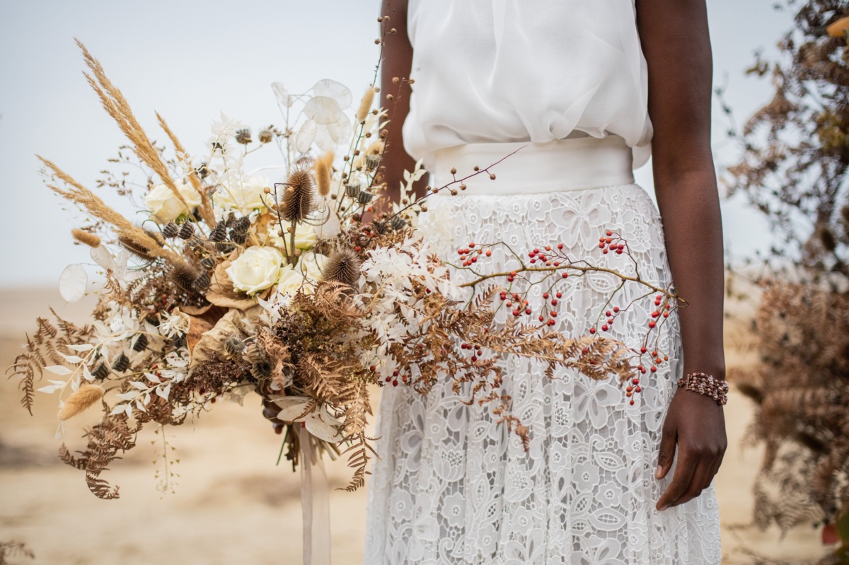 Bride holding a rustic wedding bouquet of dried flowers