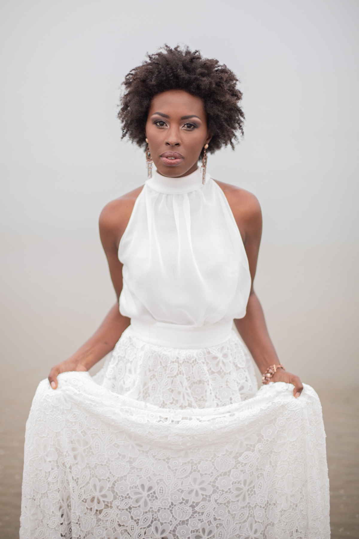 Woman in elegant white lace dress and afro hairstyle