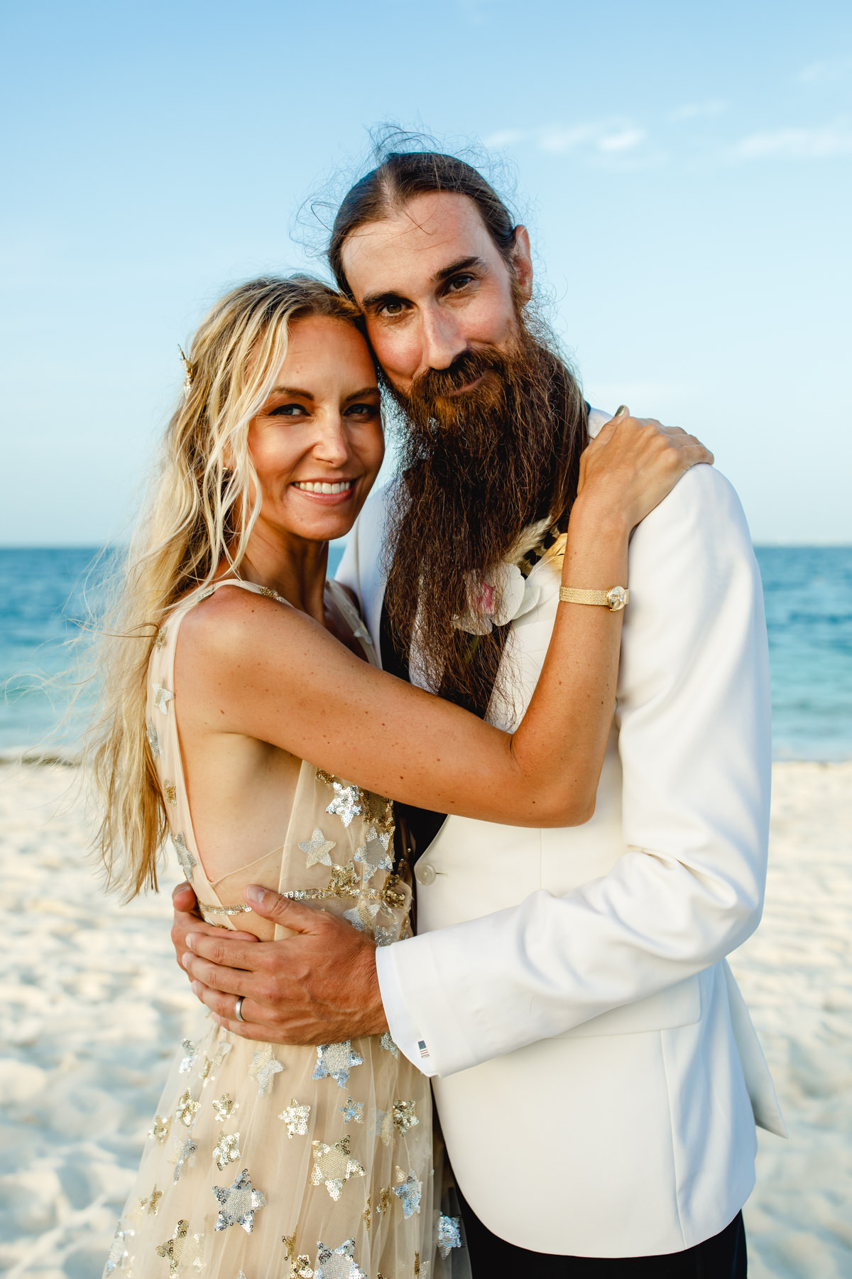 Bride and groom embracing on a sunny beach wedding day