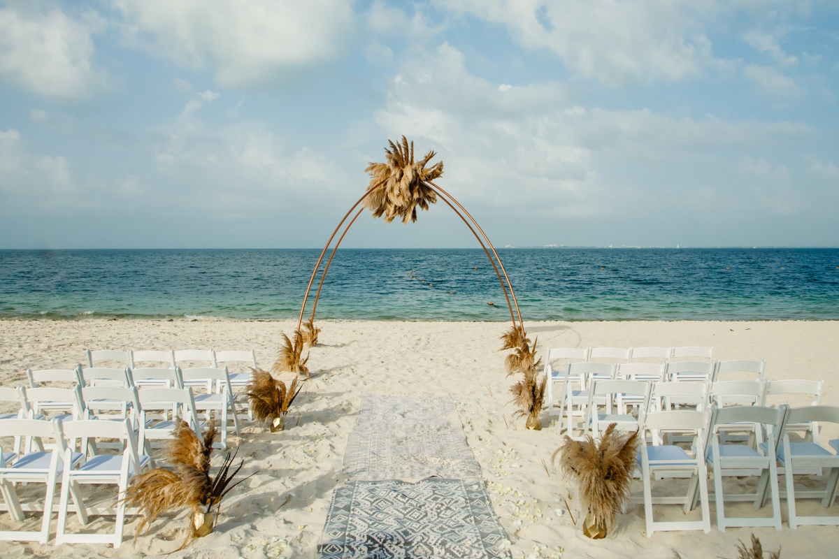 Romantic beach wedding ceremony setup with arch and ocean