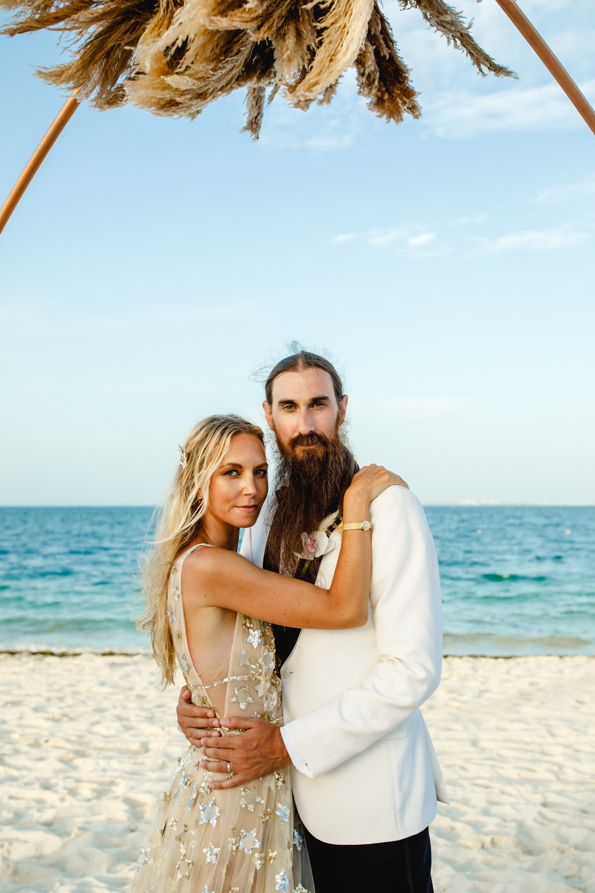 Romantic beach wedding couple embrace by the ocean