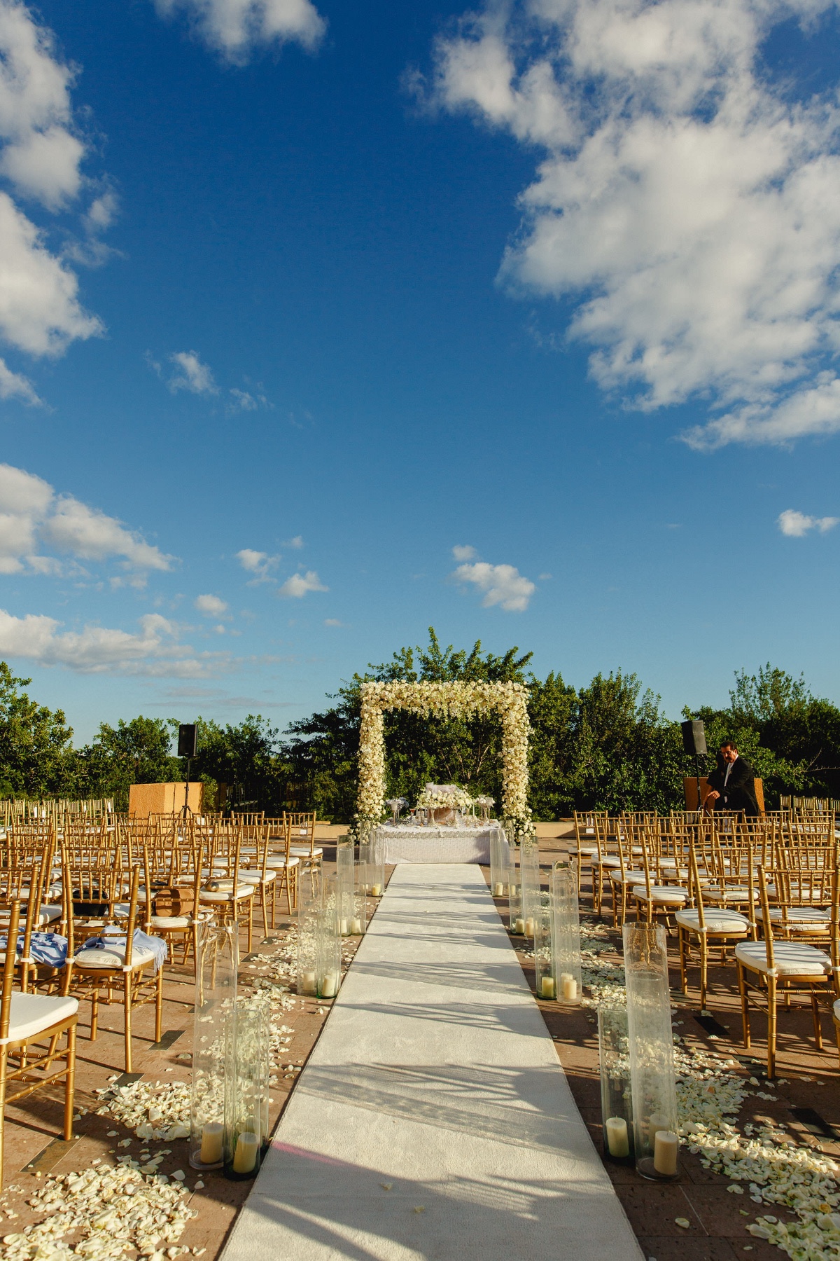 Outdoor wedding setup under blue sky and white clouds