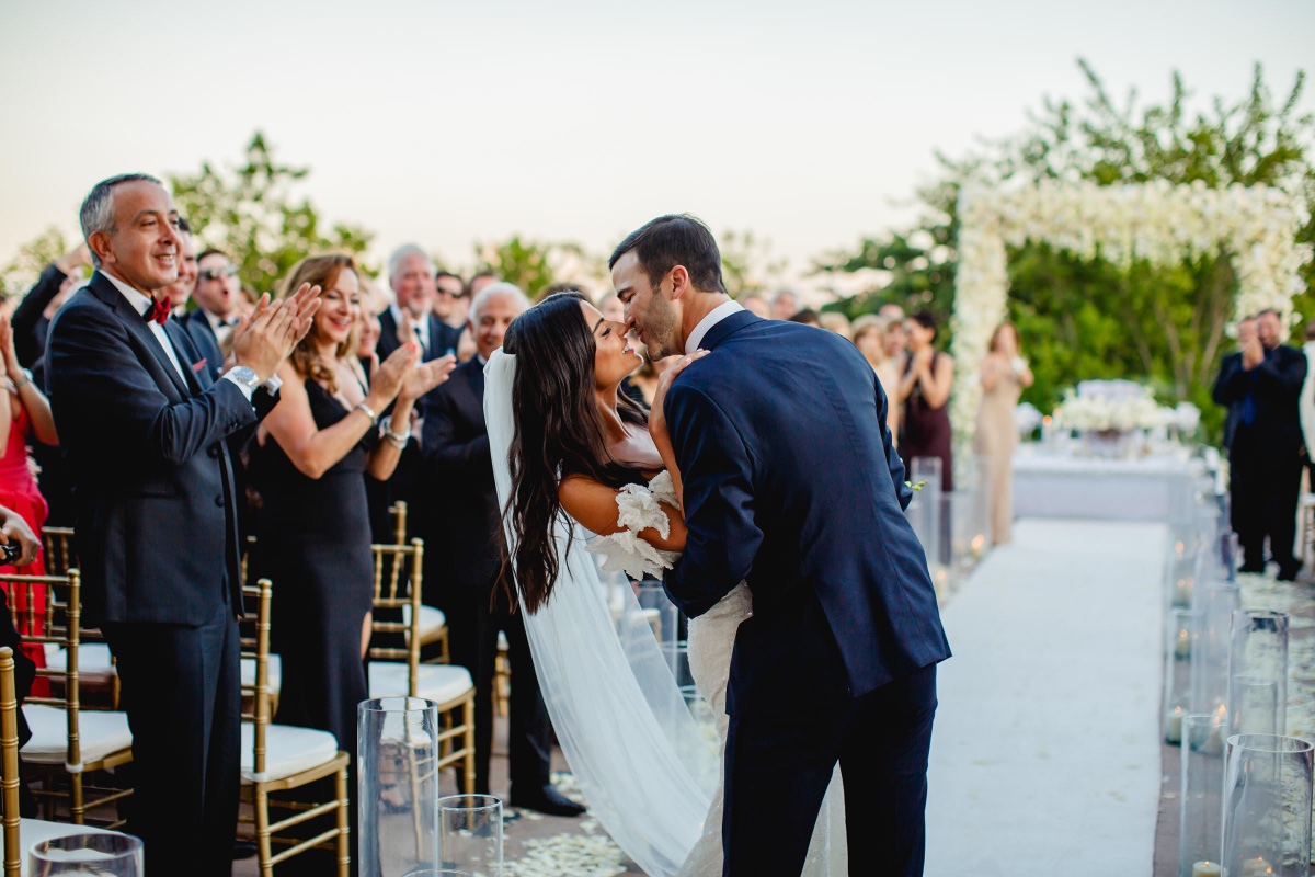 Newlyweds share their first kiss at outdoor wedding ceremony