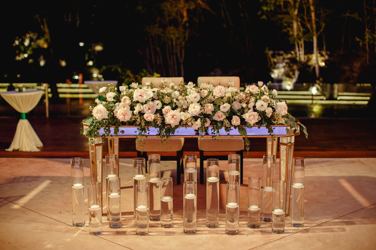 Elegant floral centerpiece with candles at outdoor wedding