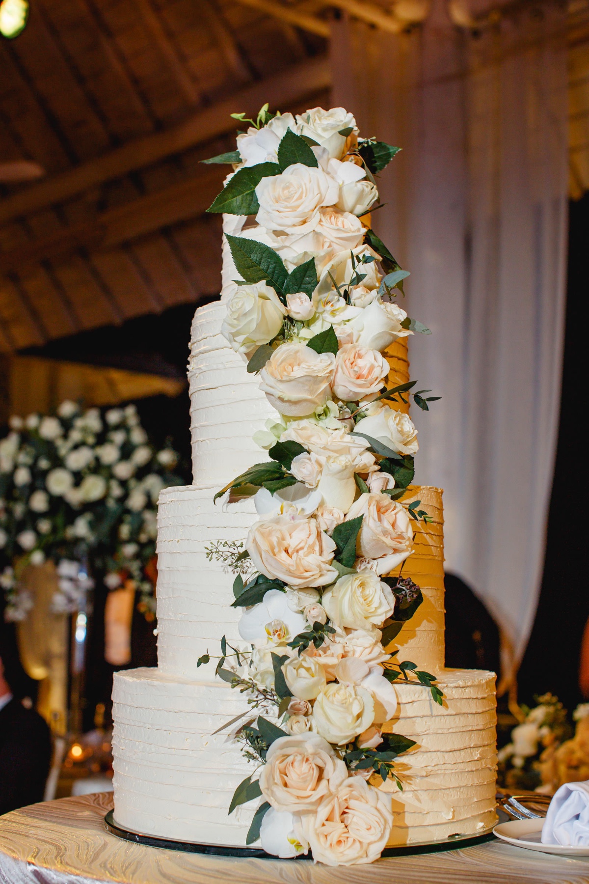 Elegant four-tier wedding cake with cascading flowers