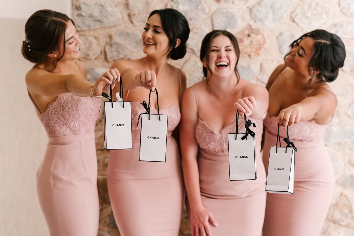 Bridesmaids in pink dresses holding Chanel gift bags
