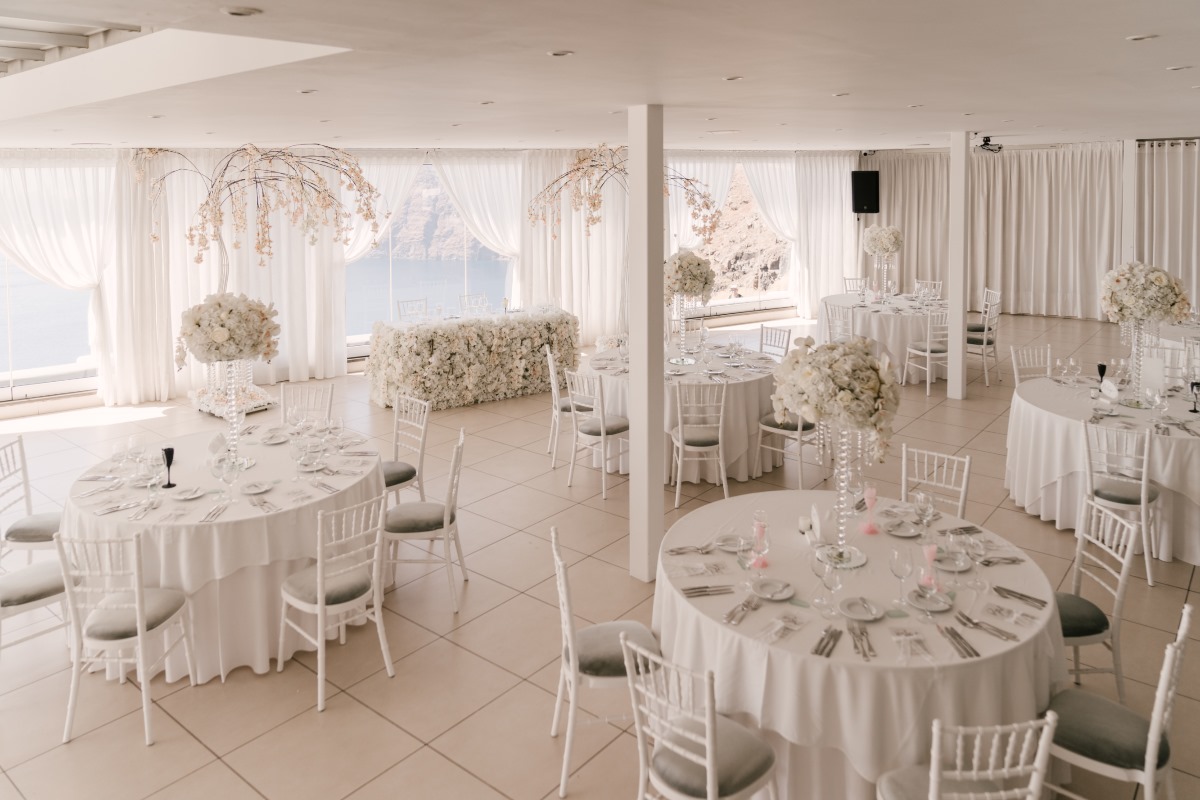 Elegant all-white wedding reception setup with floral decor