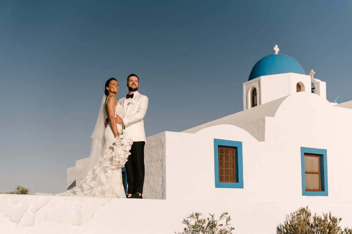 Santorini wedding couple with white church backdrop