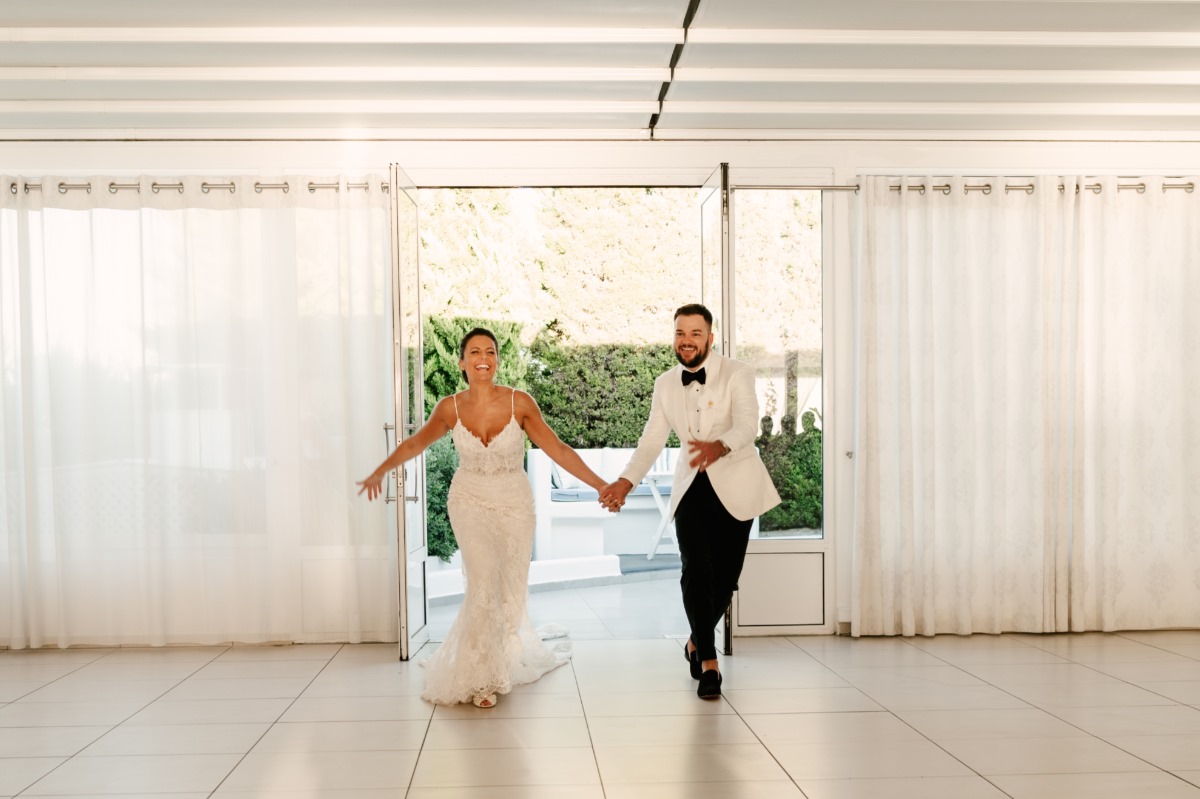 Joyful bride and groom holding hands on wedding day