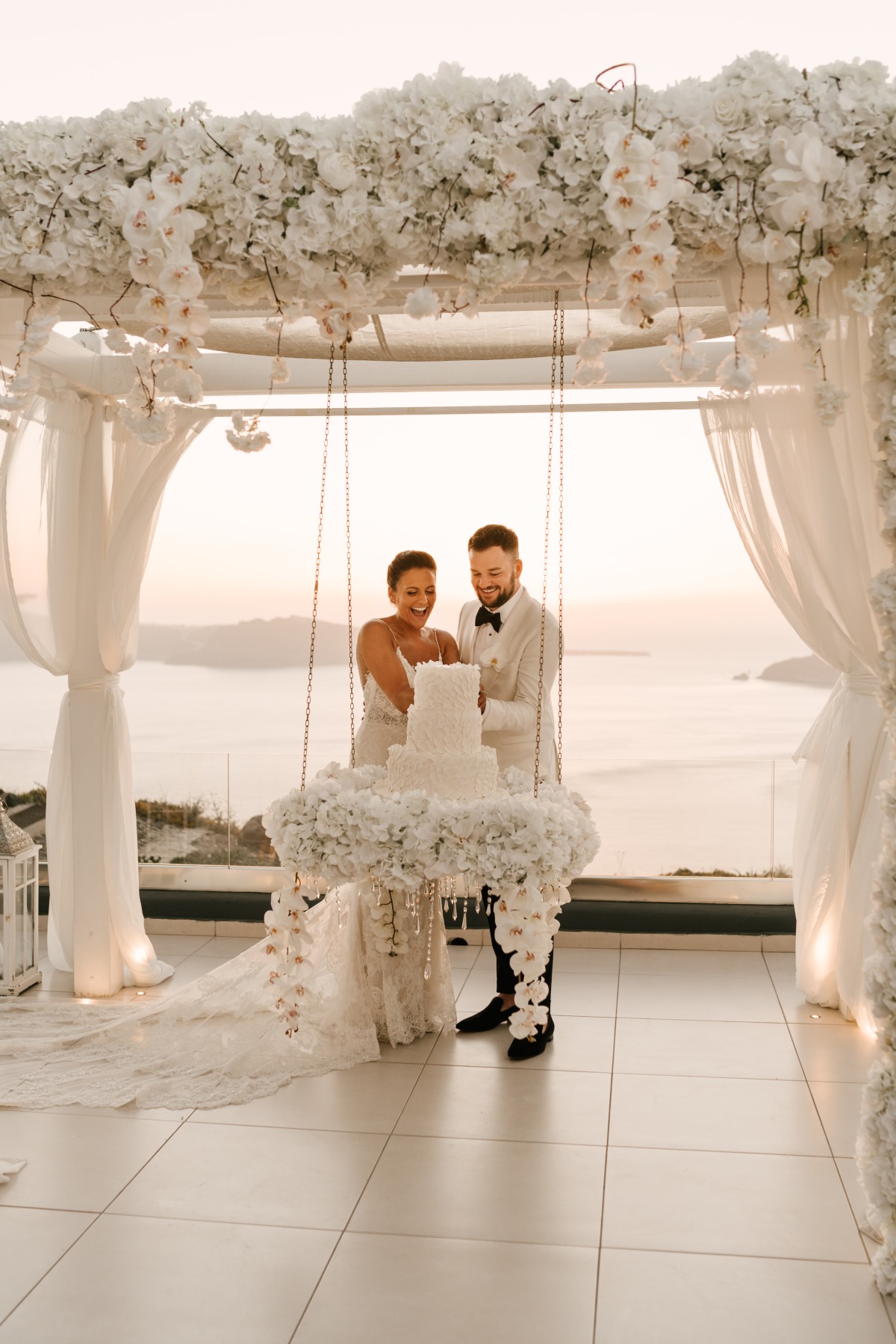 Bride and groom cutting wedding cake at Santorini ceremony