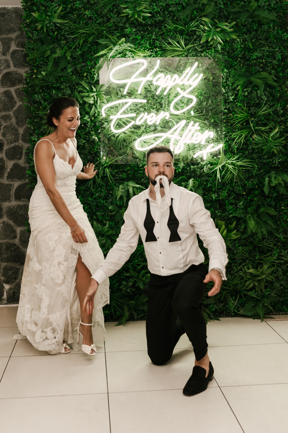 Funny wedding garter game with laughing bride and groom