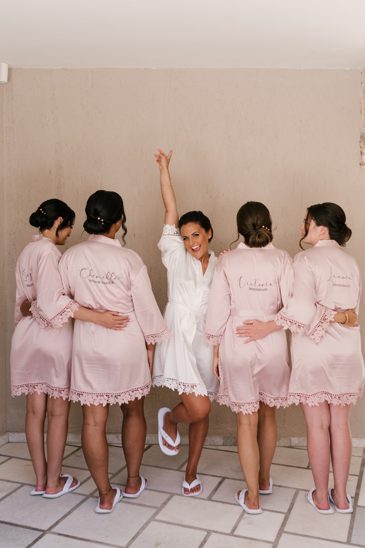 Bridesmaids celebrate in matching robes on wedding day
