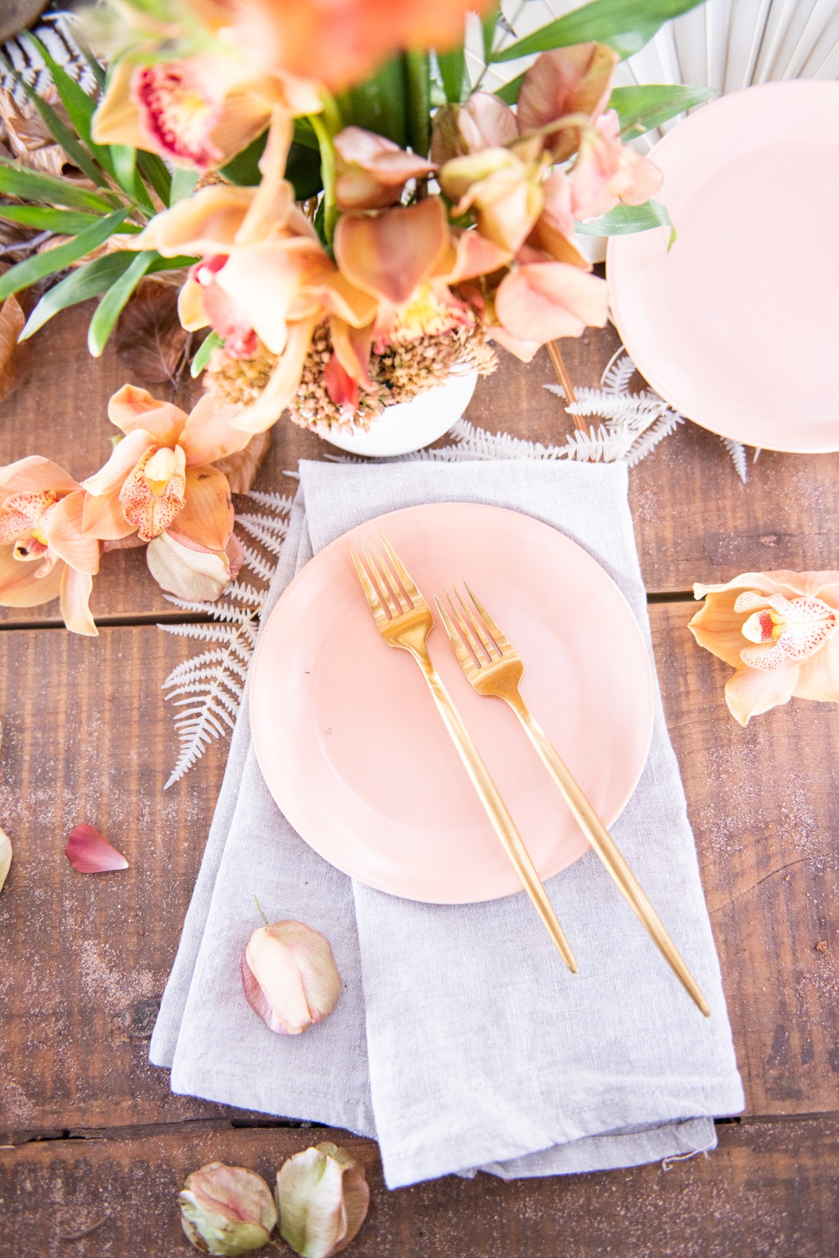 Elegant table setting with peach florals and golden forks