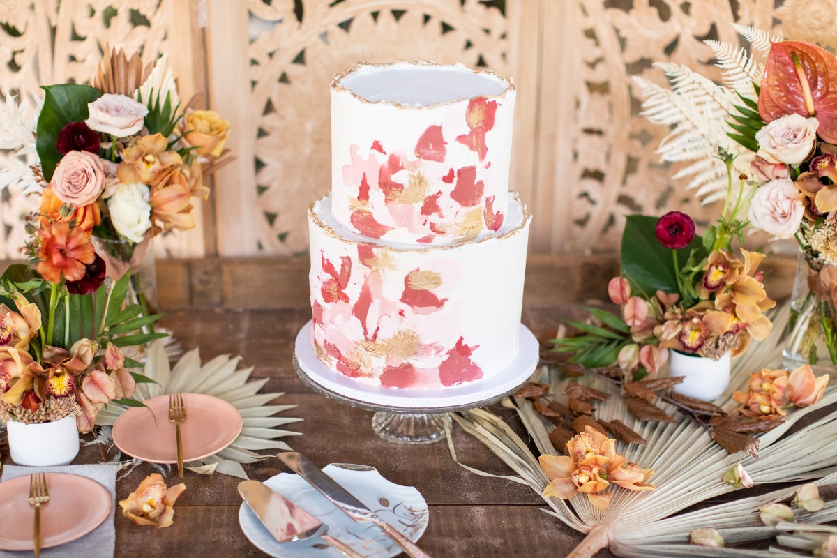 Elegant two tier wedding cake with floral accents on a wooden table