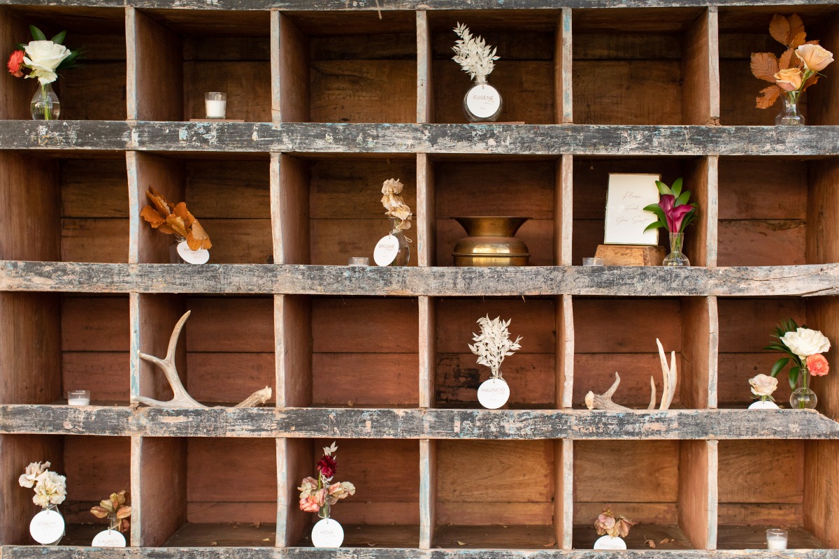 Rustic wooden shelf with flowers, candles, and decorative objects displayed