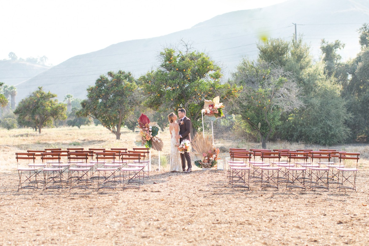 Couple at rustic outdoor wedding with mountain backdrop