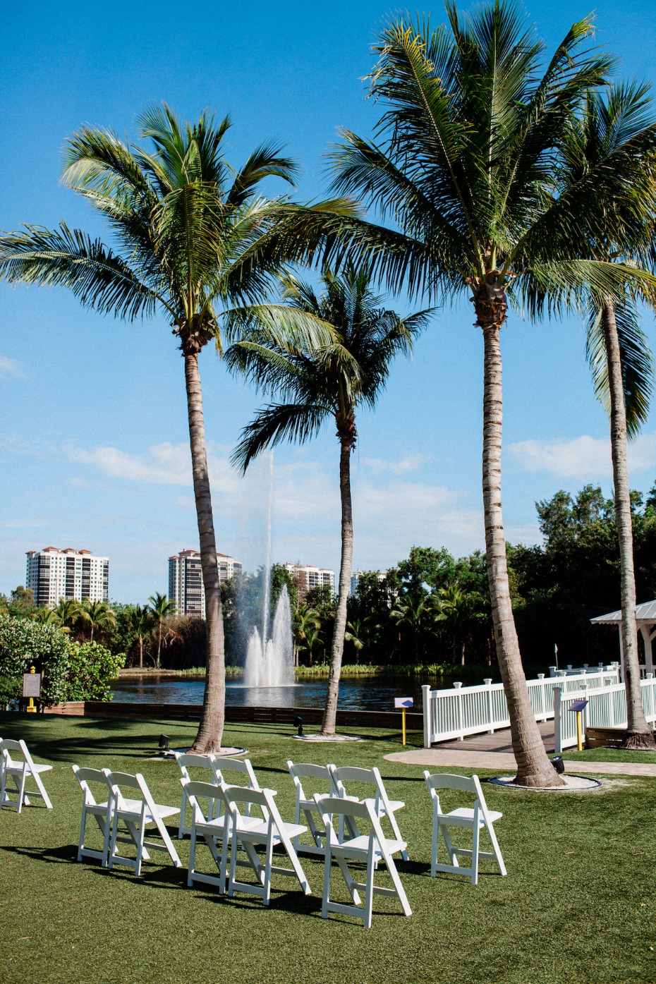 Palm trees, wedding chairs and fountain on a sunny day