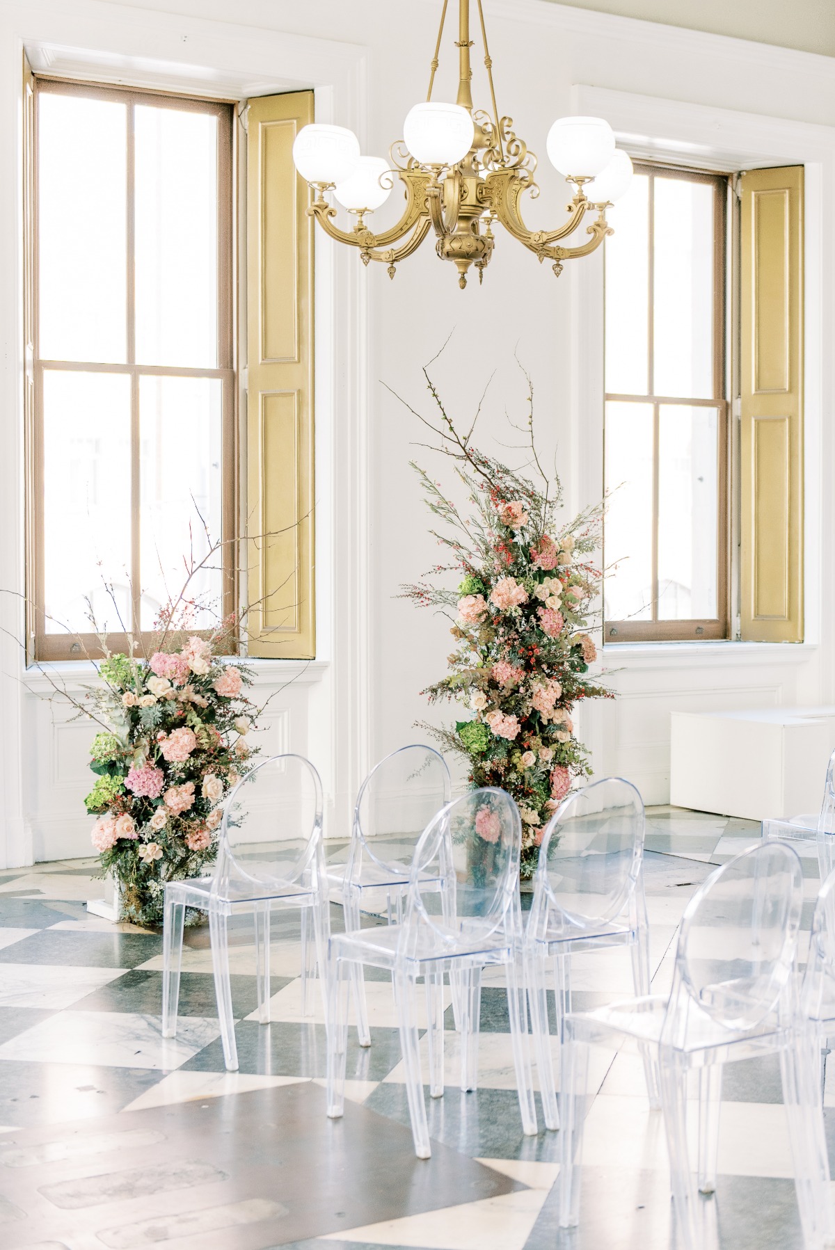 Elegant wedding setup with clear chairs and floral arrangements