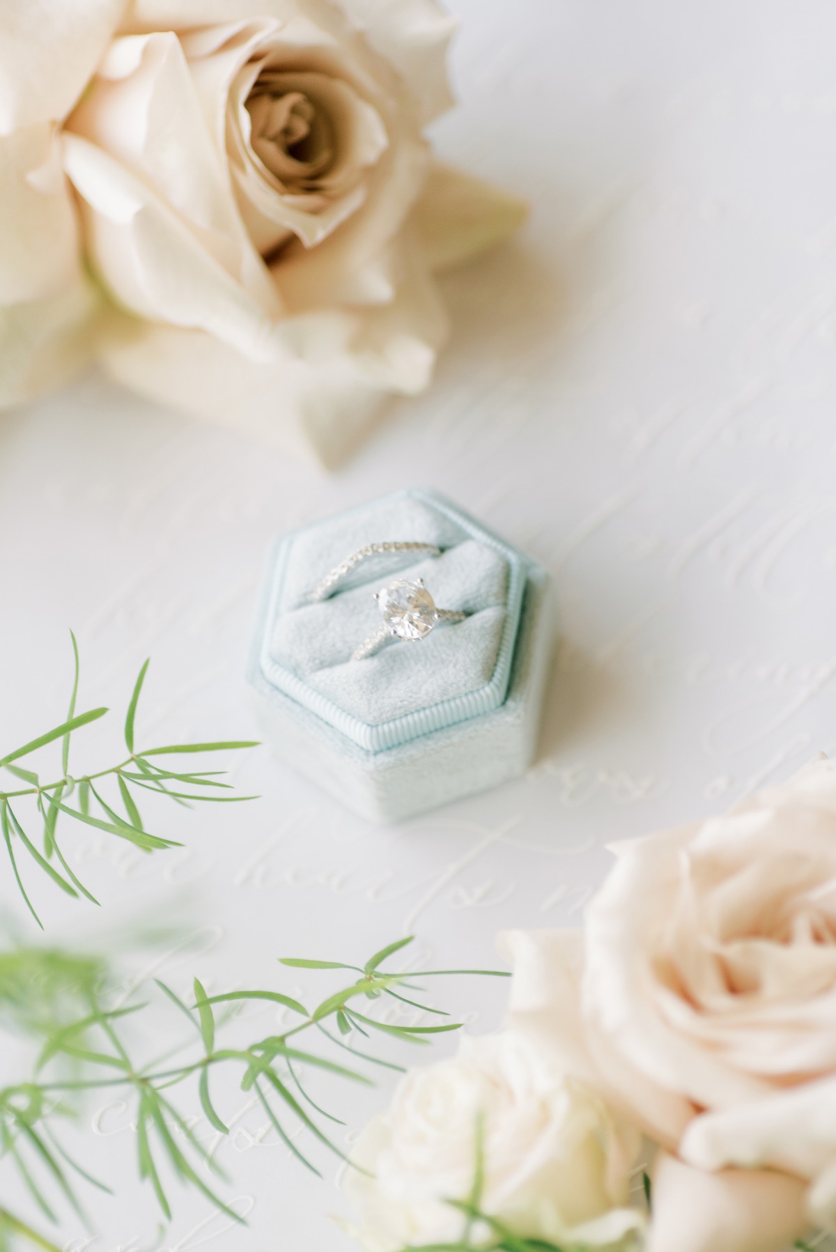 Elegant oval diamond ring in velvet box with roses