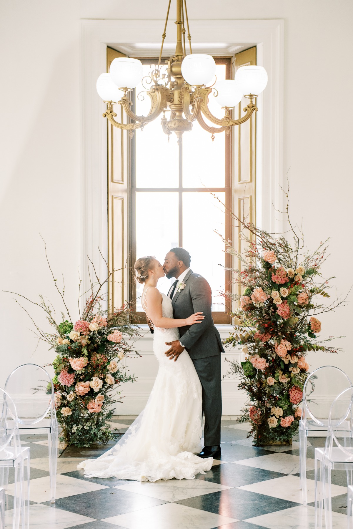 Bride and groom kissing at their elegant floral wedding