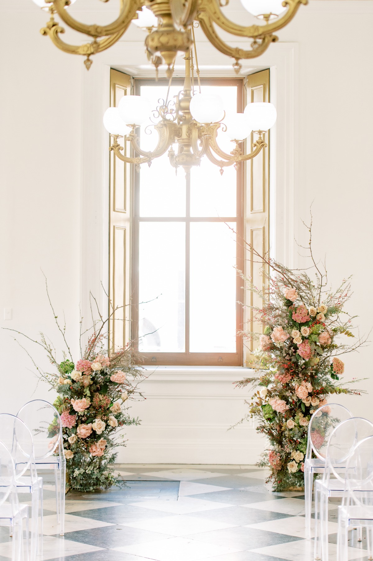 Elegant wedding aisle with floral arrangements and chandelier