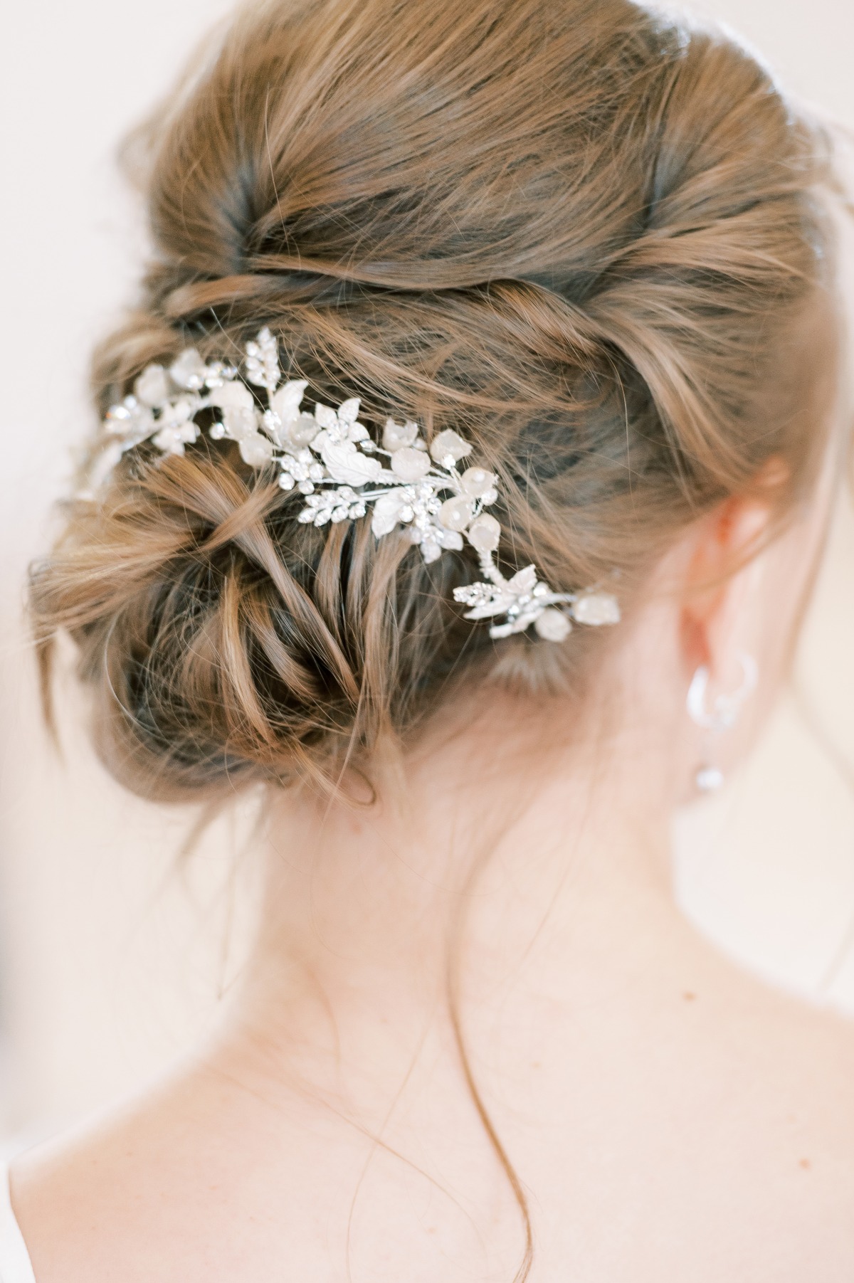 Elegant bridal updo hairstyle with floral hair accessory