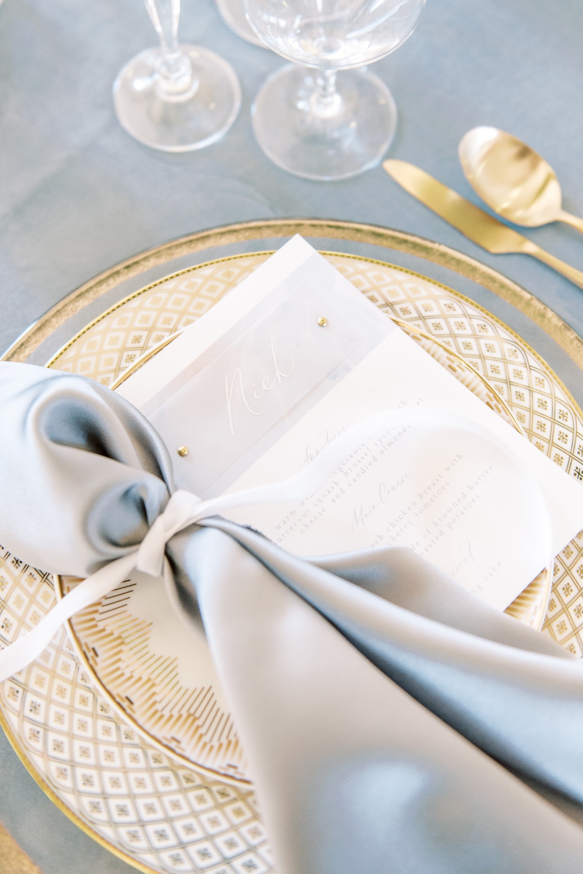Elegant wedding table setting with gold plate and blue napkin