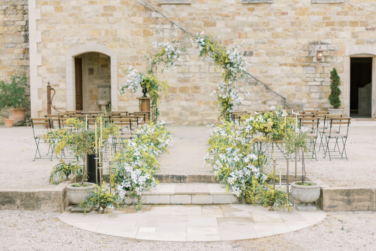 Rustic outdoor wedding ceremony setup with floral arch