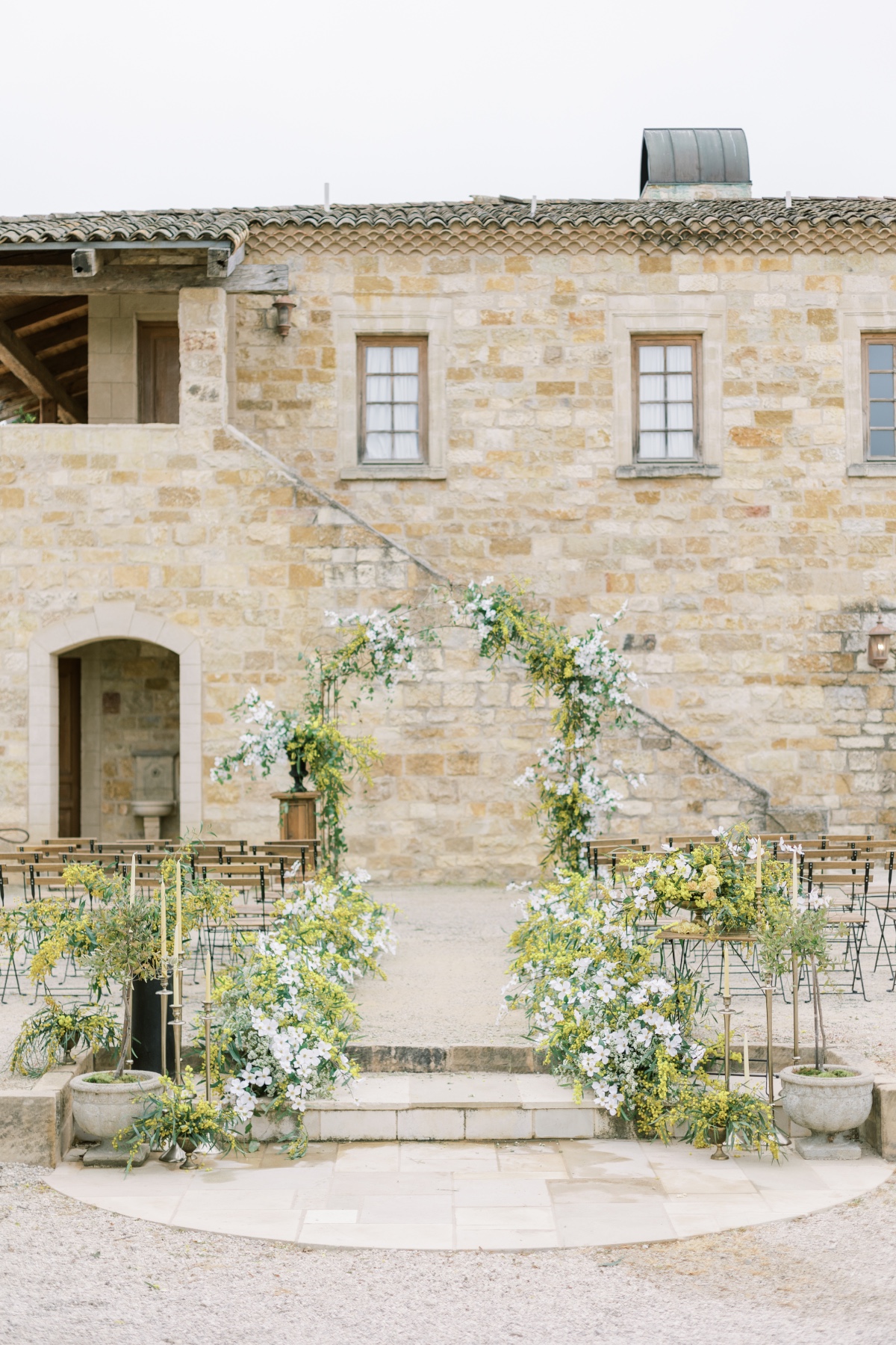 Rustic outdoor wedding ceremony setup with floral arch