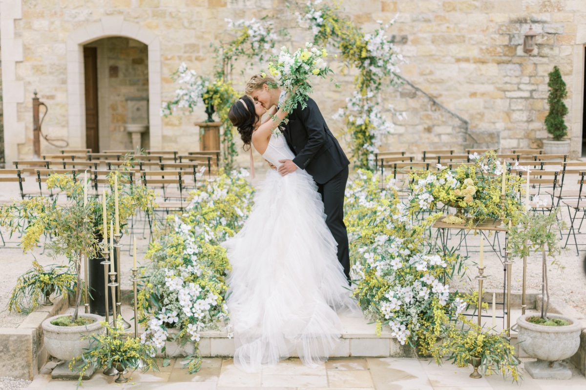 Bride and groom kissing at romantic outdoor ceremony