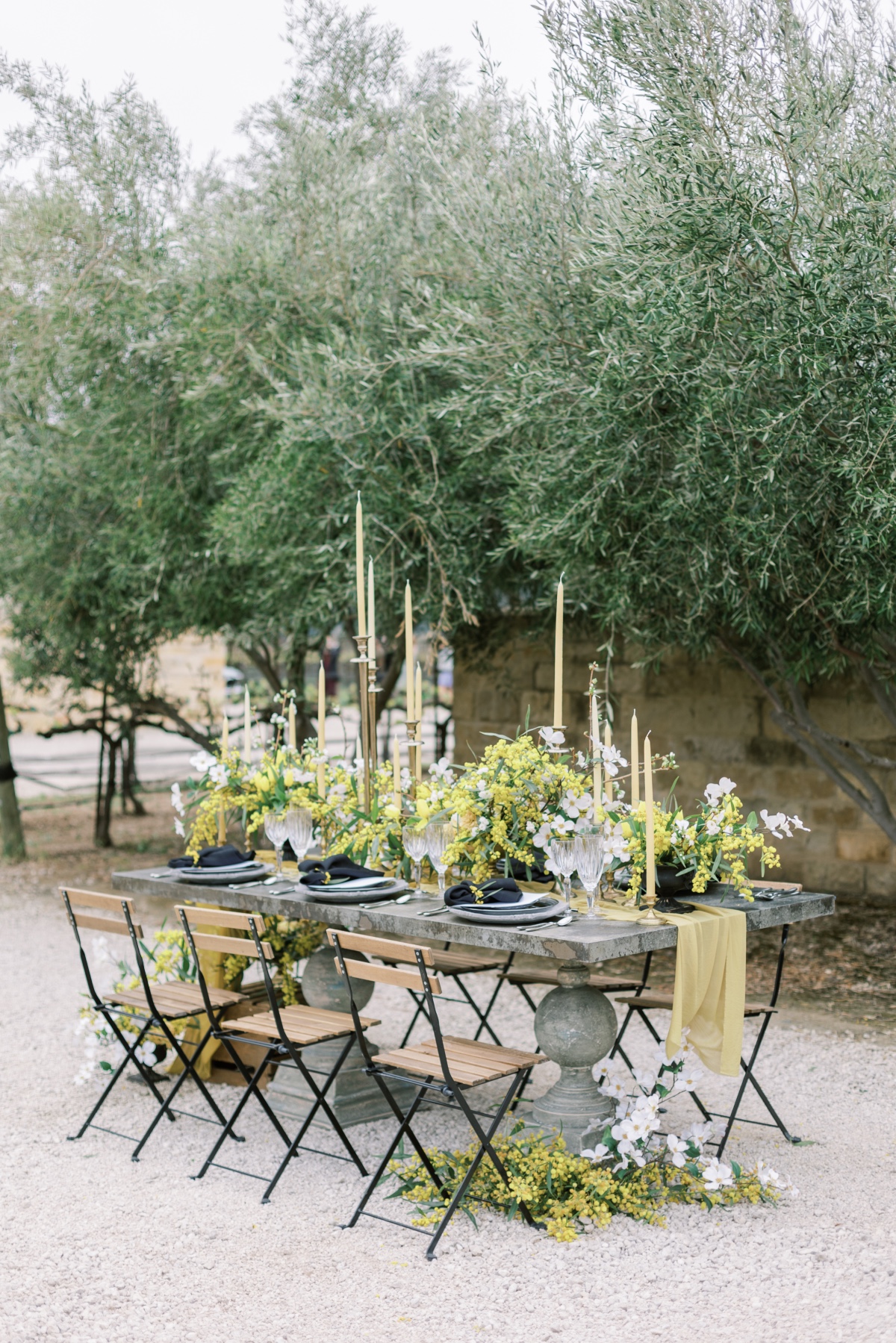 Outdoor wedding table setting with yellow and white flowers