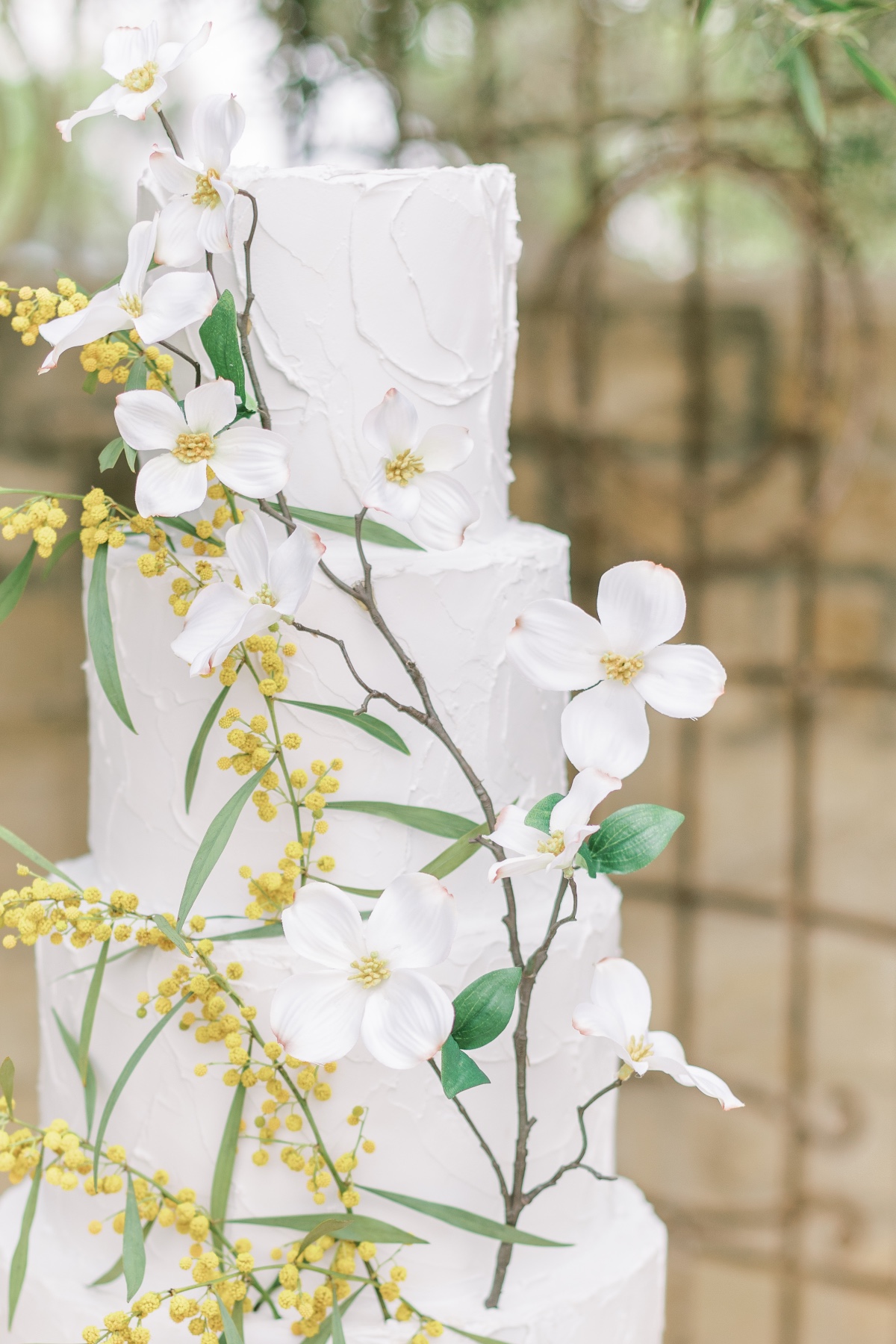 Elegant white wedding cake decorated with dogwood flowers